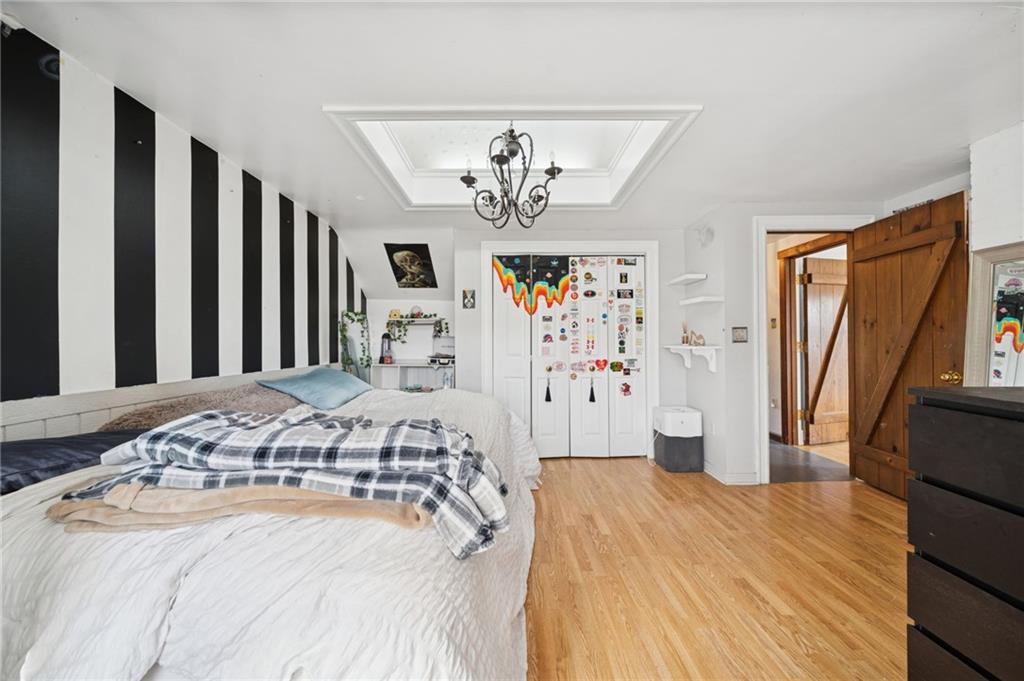 1512 Abers Creek Road Pittsburgh, PA 15239 - Photo 23 of 45 a bedroom with a large bed and a chandelier