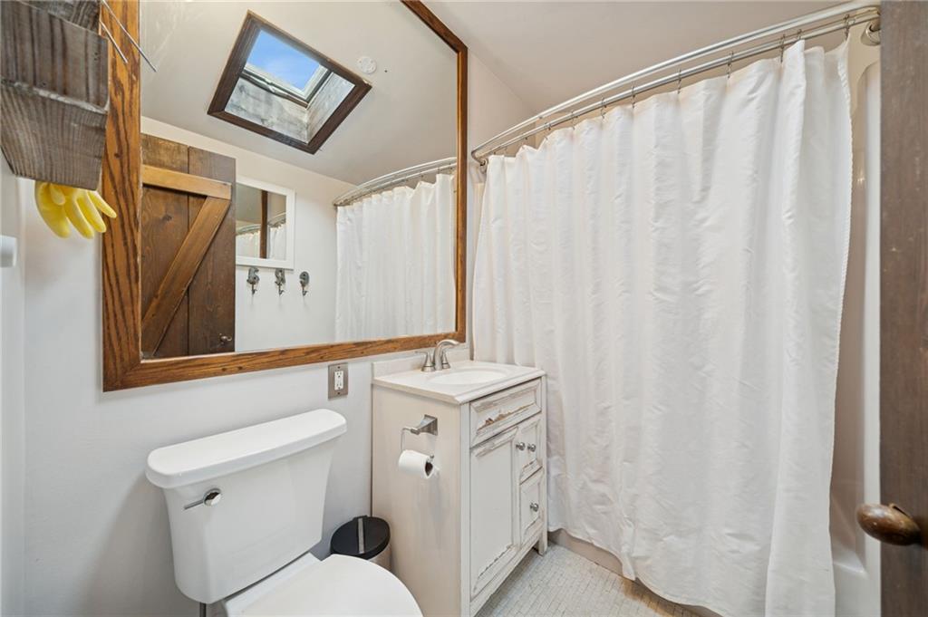 1512 Abers Creek Road Pittsburgh, PA 15239 - Photo 27 of 45 a bathroom with a sink a toilet and shower curtain