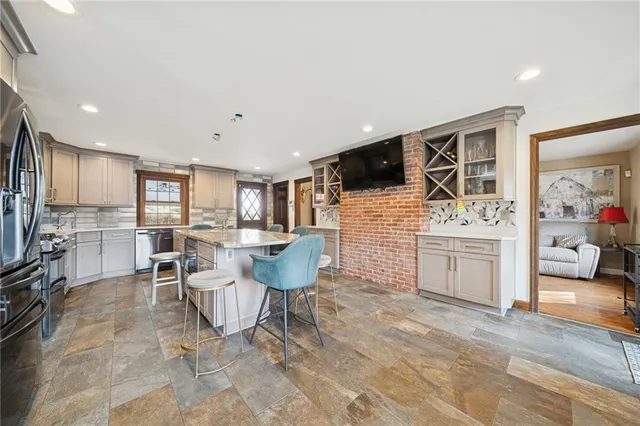 a living room with furniture a flat screen tv and kitchen view