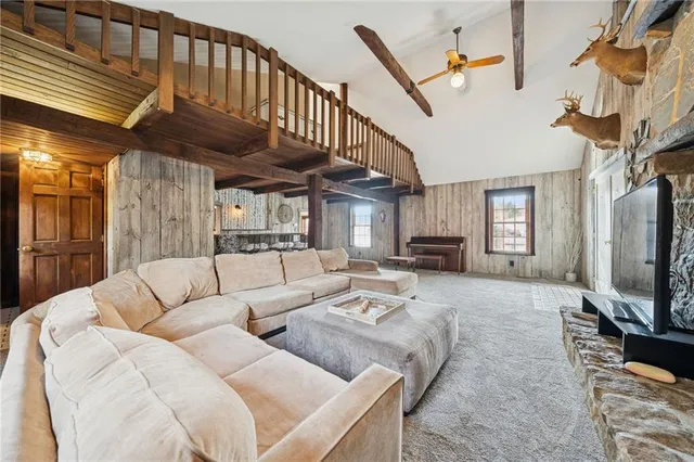 a living room with furniture a flat screen tv and a refrigerator