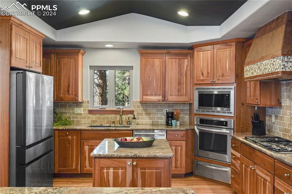 9450 Morgan Road Colorado Springs, CO 80908 - Photo 17 of 49 a kitchen with granite countertop stainless steel appliances a stove sink and refrigerator