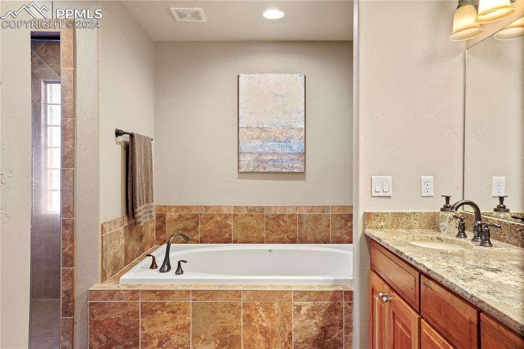 9450 Morgan Road Colorado Springs, CO 80908 - Photo 23 of 49 a bathroom with a granite countertop tub sink and mirror