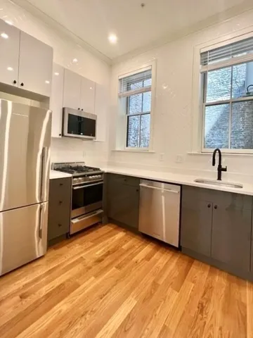 a kitchen with stainless steel appliances a stove sink and microwave