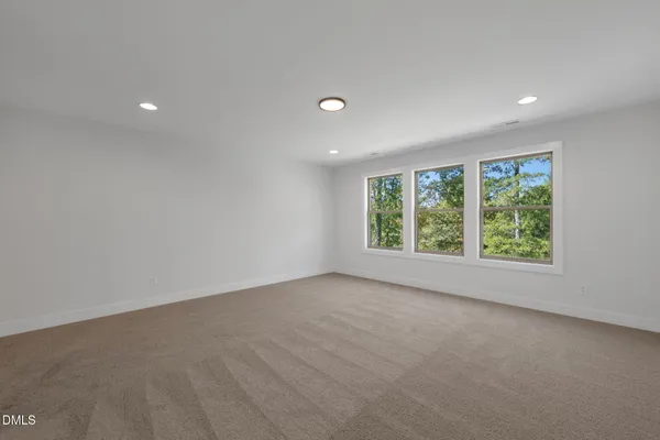 a view of a big room with windows and chandelier fan