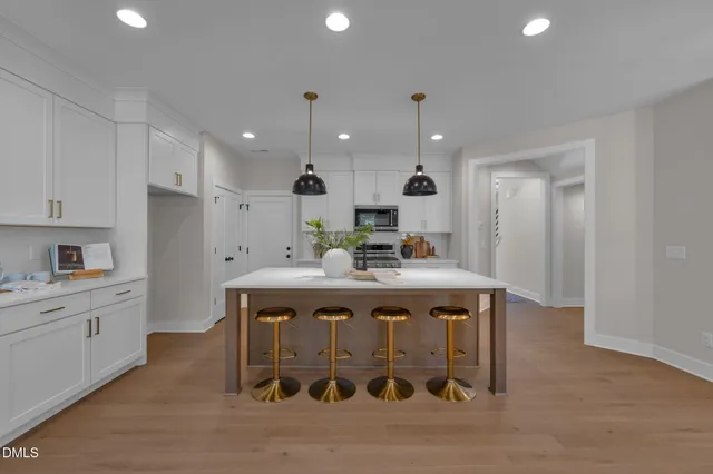 a kitchen with stainless steel appliances granite countertop a sink a stove a refrigerator and white cabinets