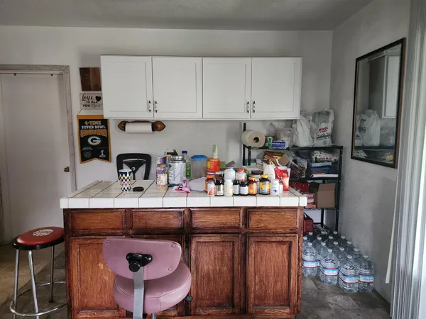 a kitchen with stainless steel appliances granite countertop a table chairs refrigerator and sink