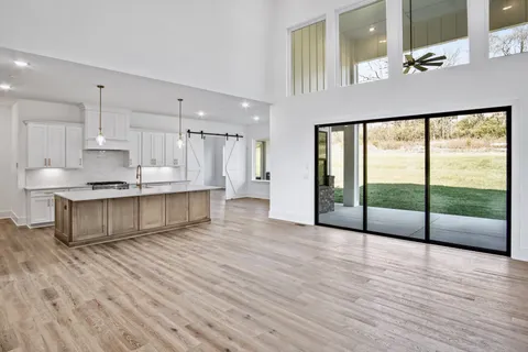 a large kitchen with a sink and dishwasher a stove with wooden floor