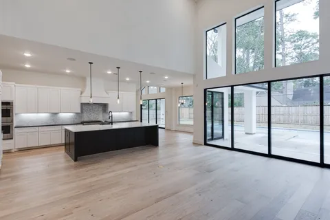 a view of a dining room with furniture large windows and wooden floor