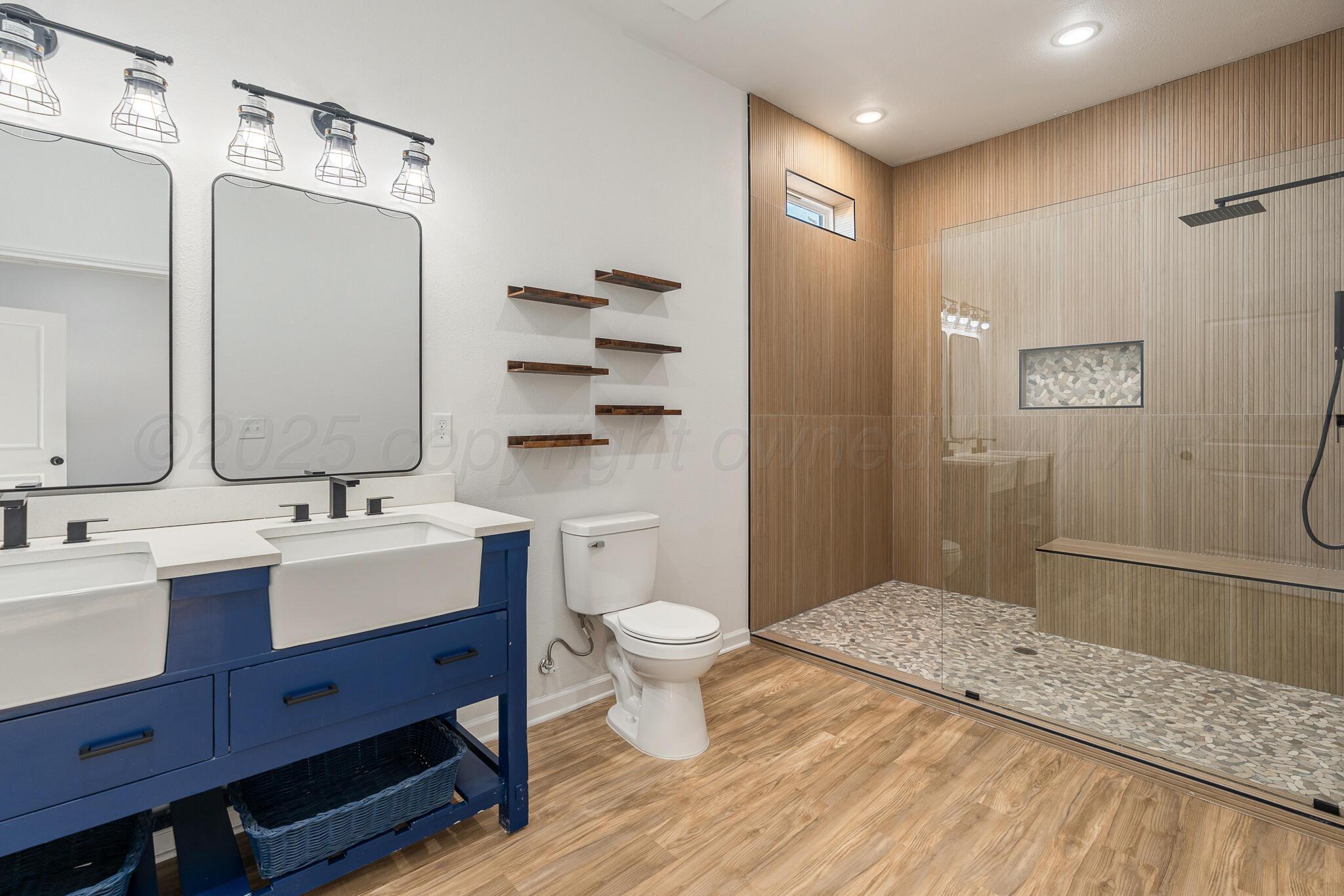 220 Sims Street Clarendon, TX 79226 - Photo 11 of 17 a bathroom with a sink a toilet a mirror and shower