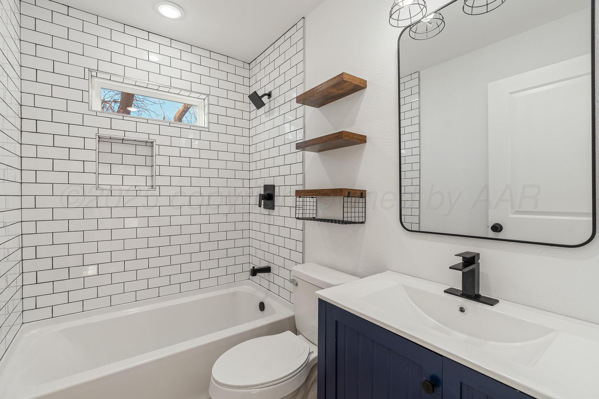220 Sims Street Clarendon, TX 79226 - Photo 14 of 17 a bathroom with a sink a toilet and bathtub