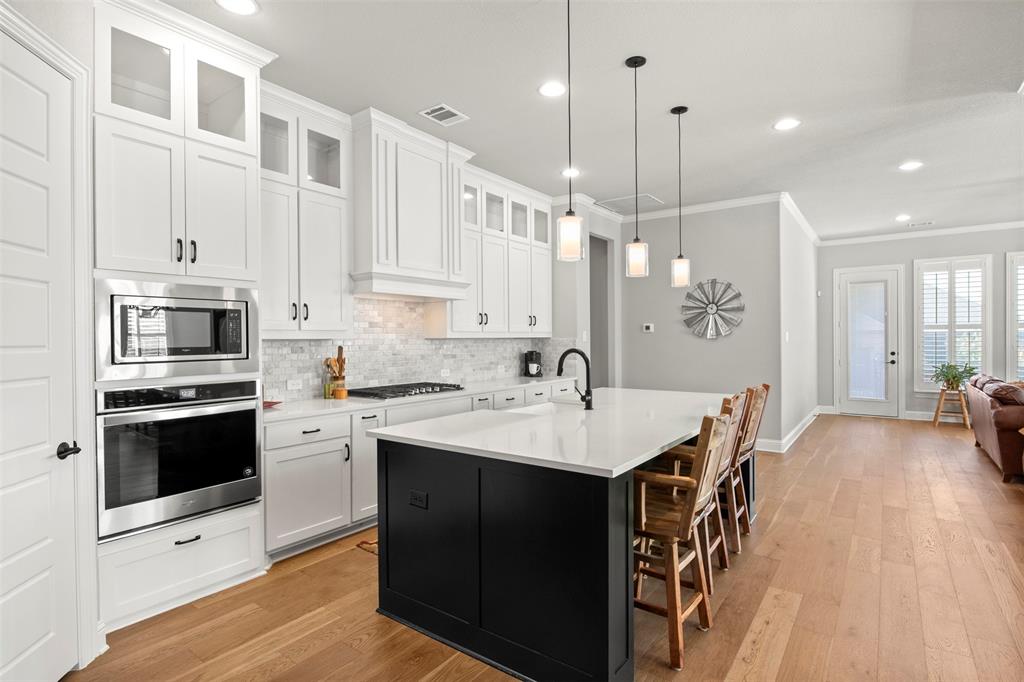 2002 Kati Jane Lane Midlothian, TX 76065 - Photo 19 of 30 a kitchen with stainless steel appliances kitchen island granite countertop a stove a sink a refrigerator and white cabinets with wooden floor