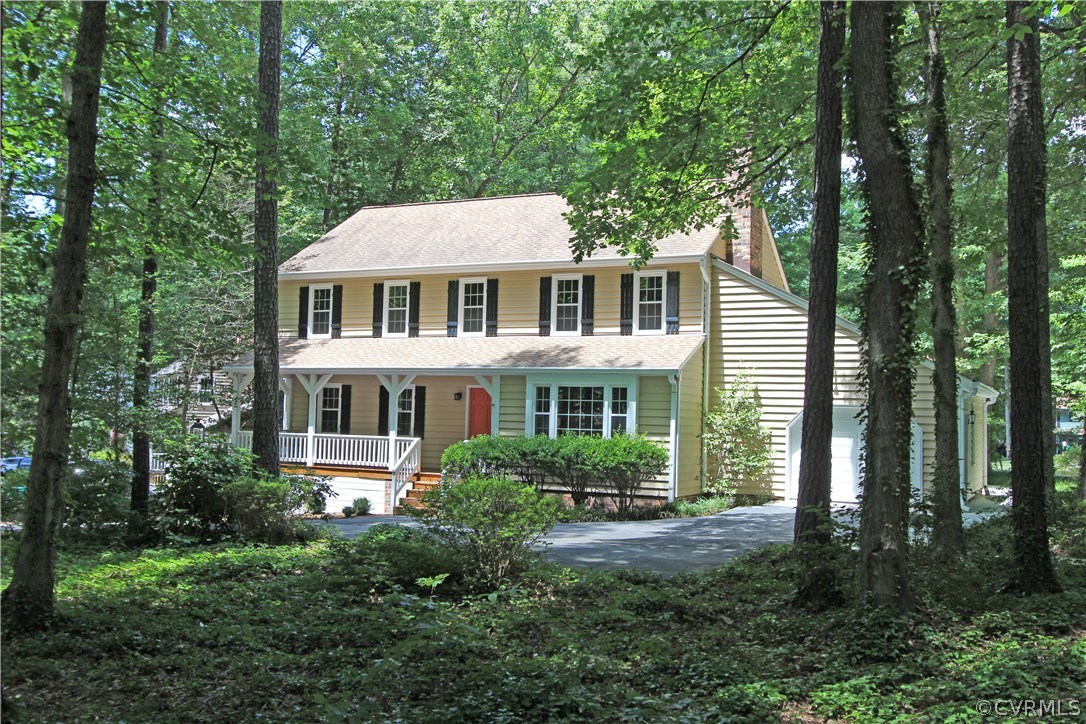 a front view of a house with a yard and trees