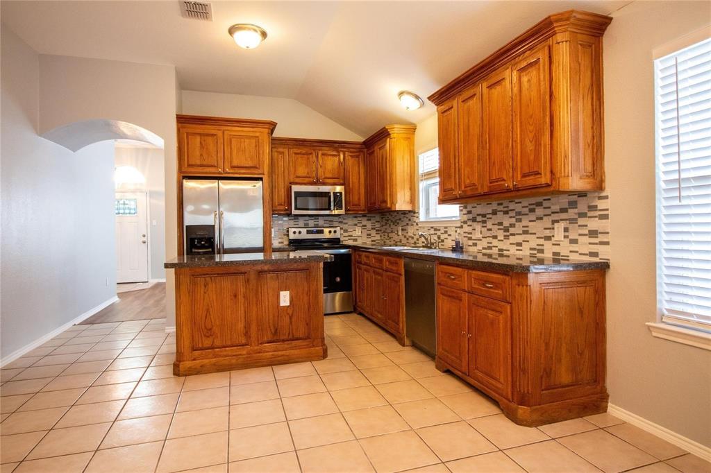 1933 Joe Pool Drive Little Elm, TX 75068 - Photo 10 of 23 a kitchen with stainless steel appliances granite countertop a stove a sink and a microwave