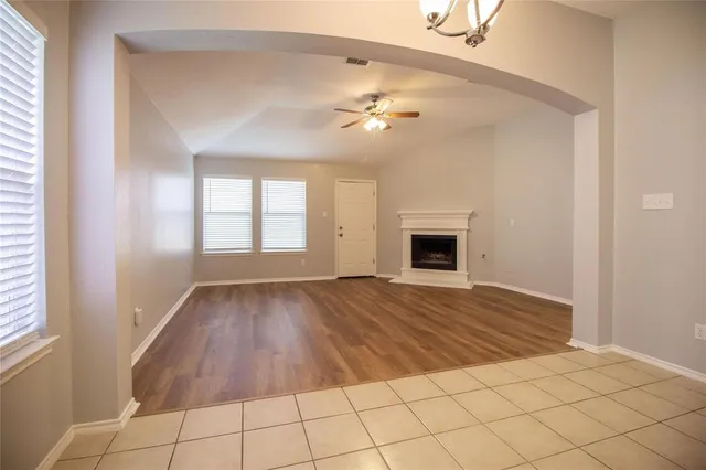 a view of an empty room with window and fireplace