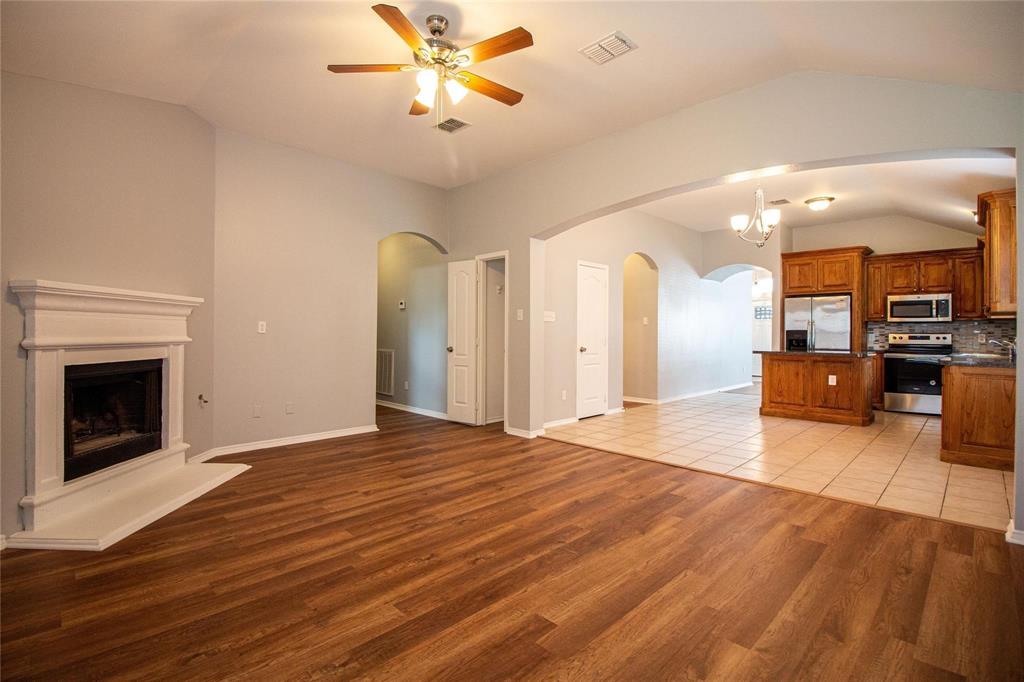 1933 Joe Pool Drive Little Elm, TX 75068 - Photo 7 of 23 a view of a livingroom with a fireplace a ceiling fan and wooden floor