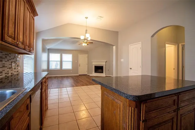 a view of a living room a kitchen with wooden floor and a window