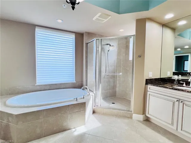 a bathroom with a tub a sink and a shower