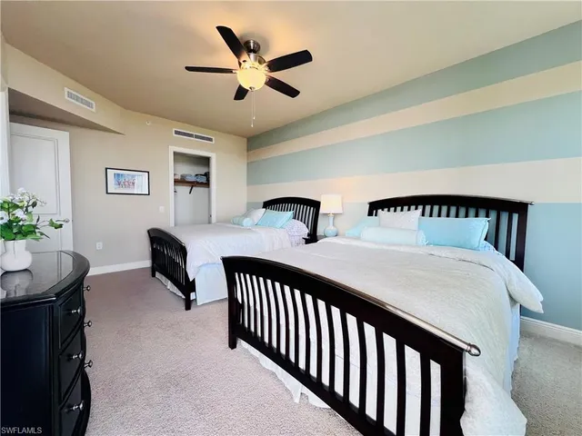 a bedroom with two beds and a potted plant