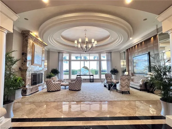 a living room with fireplace furniture chandelier and a large window