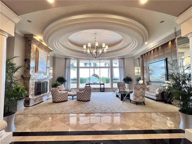 a living room with fireplace furniture chandelier and a large window