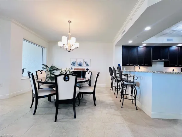 a dining room with furniture a chandelier and window