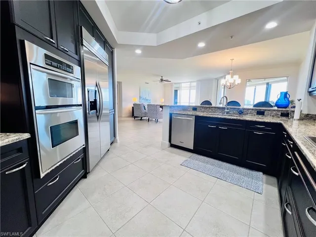 a kitchen with stainless steel appliances kitchen island granite countertop a sink and stove top oven