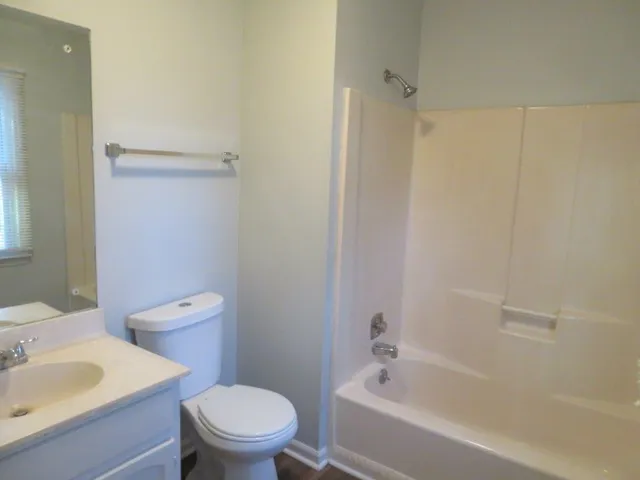 a white toilet sitting next to a bath tub