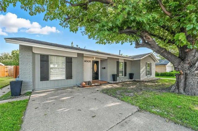 a front view of a house with a garden and yard