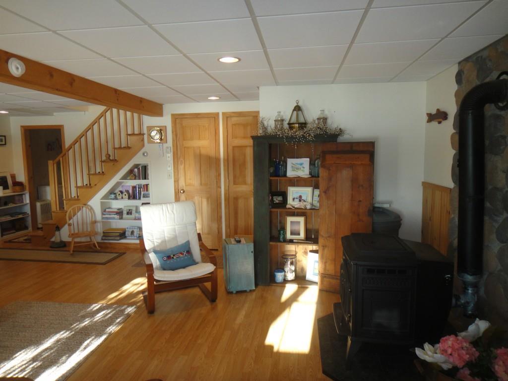 378 Griffin Ridge Road Mapleton, ME 04757 - Photo 17 of 27 Pellet stove in basement living area.