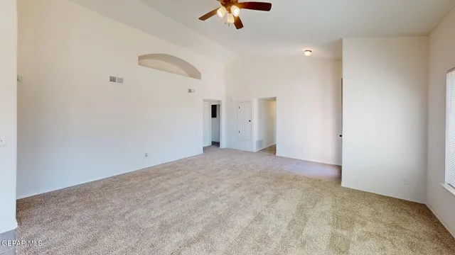 a view of a room with a ceiling fan and window