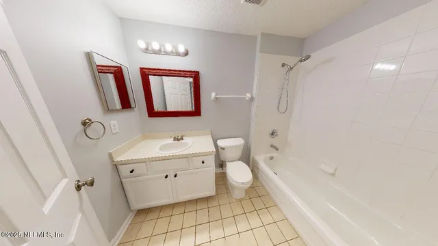 a bathroom with a bathtub sink mirror vanity and toilet
