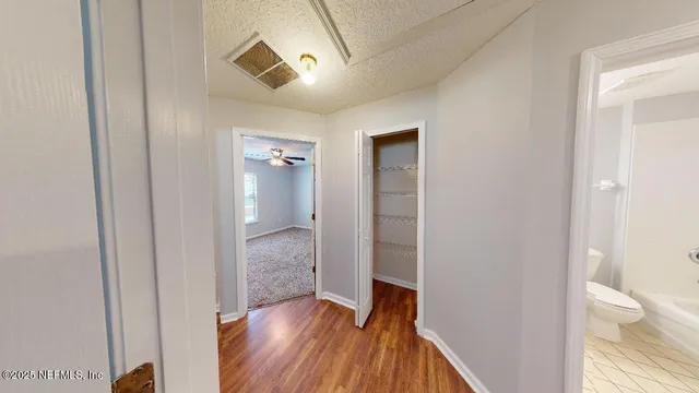 a view of a hallway with wooden floor