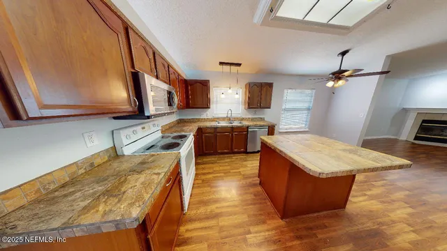 a kitchen with stainless steel appliances granite countertop a sink a stove top oven a counter space and cabinets