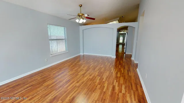 a view of empty room with wooden floor