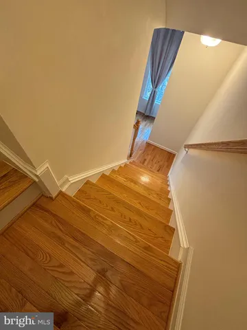 a view of staircase and utility room with wooden floor