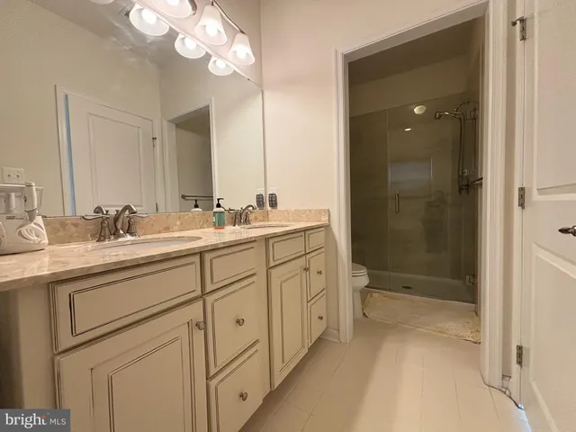 a bathroom with a double vanity sink mirror and shower