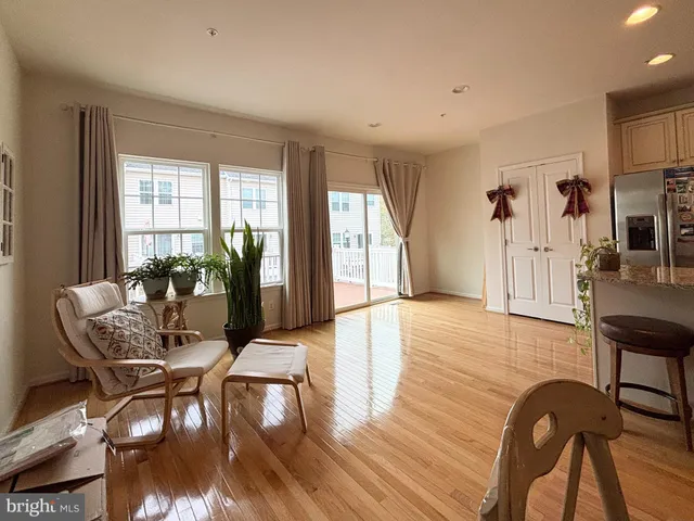 a living room with furniture dining table and a large window