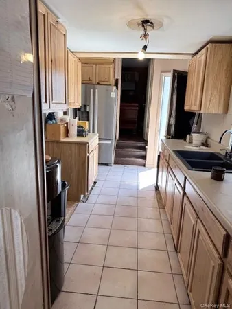 a kitchen with a sink a refrigerator and cabinets