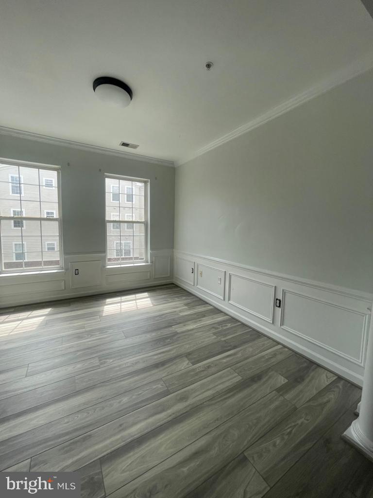 9713 Handerson Place, Unit 304 Manassas Park, VA 20111 - Photo 11 of 14 an empty room with wooden floor and windows