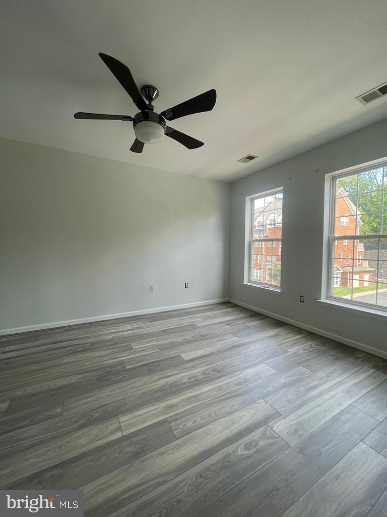 9713 Handerson Place, Unit 304 Manassas Park, VA 20111 - Photo 7 of 14 an empty room with wooden floor fan and windows