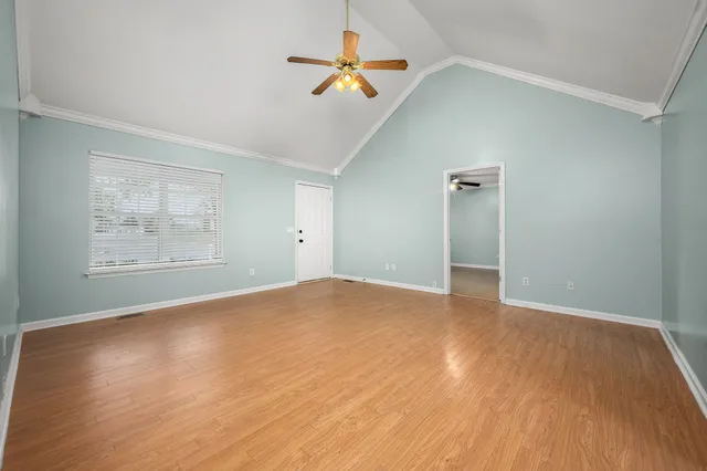 a view of empty room with wooden floor
