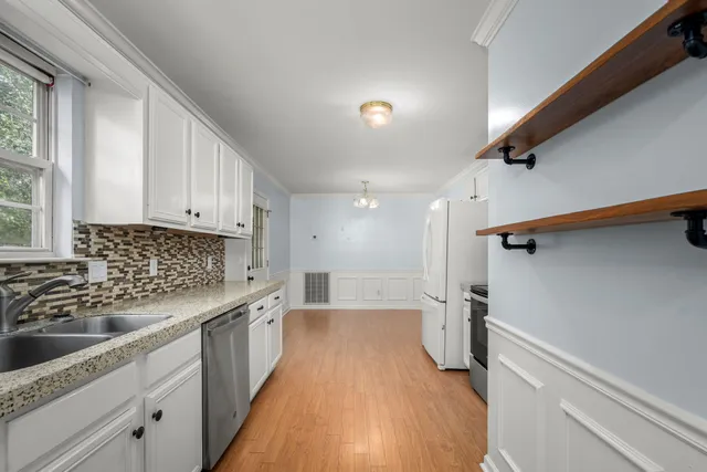 a view of a big room with wooden floor and windows