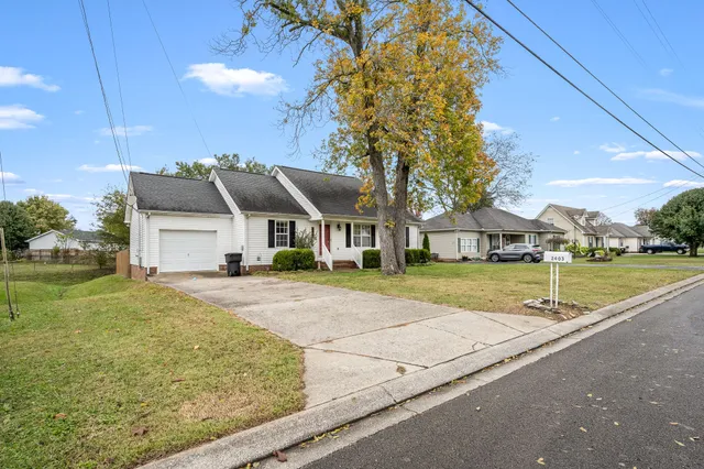 a view of a house with a yard and tree