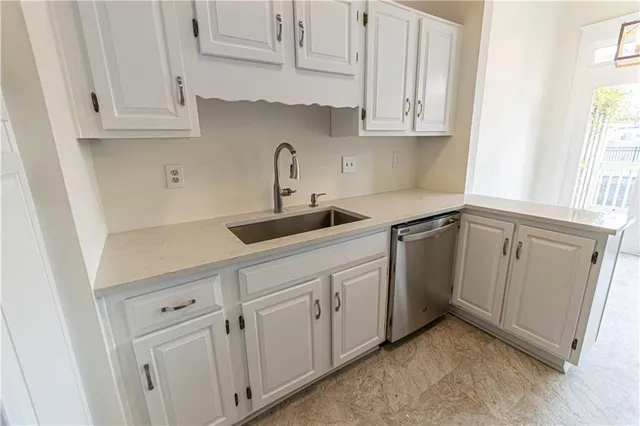 a kitchen with white cabinets and white appliances