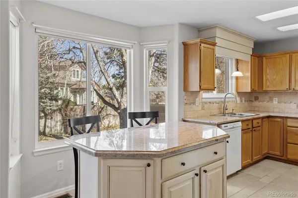 a kitchen with granite countertop white cabinets and stainless steel appliances