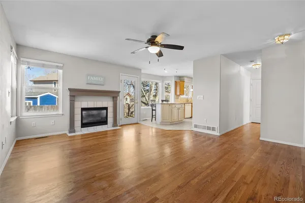a view of empty room with wooden floor and fan