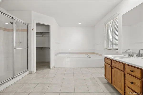 a spacious bathroom with a granite countertop sink mirror and bathtub
