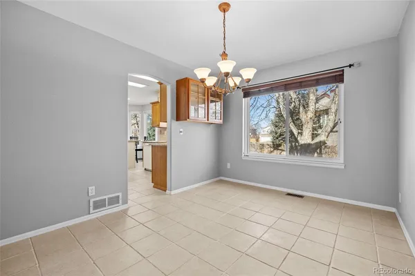 a view of an empty room with a chandelier fan