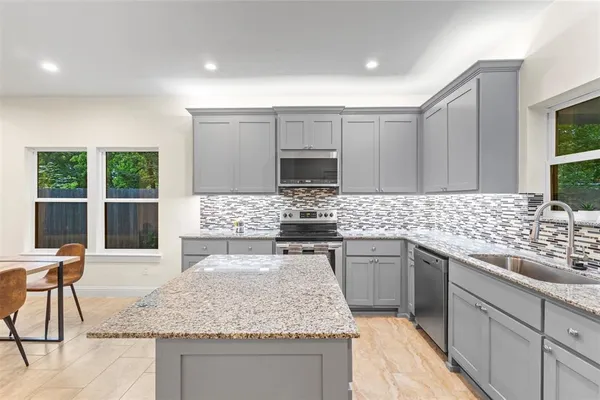 a kitchen with stainless steel appliances granite countertop a sink stove and microwave