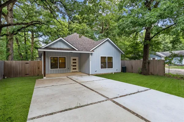a front view of a house with a yard and trees